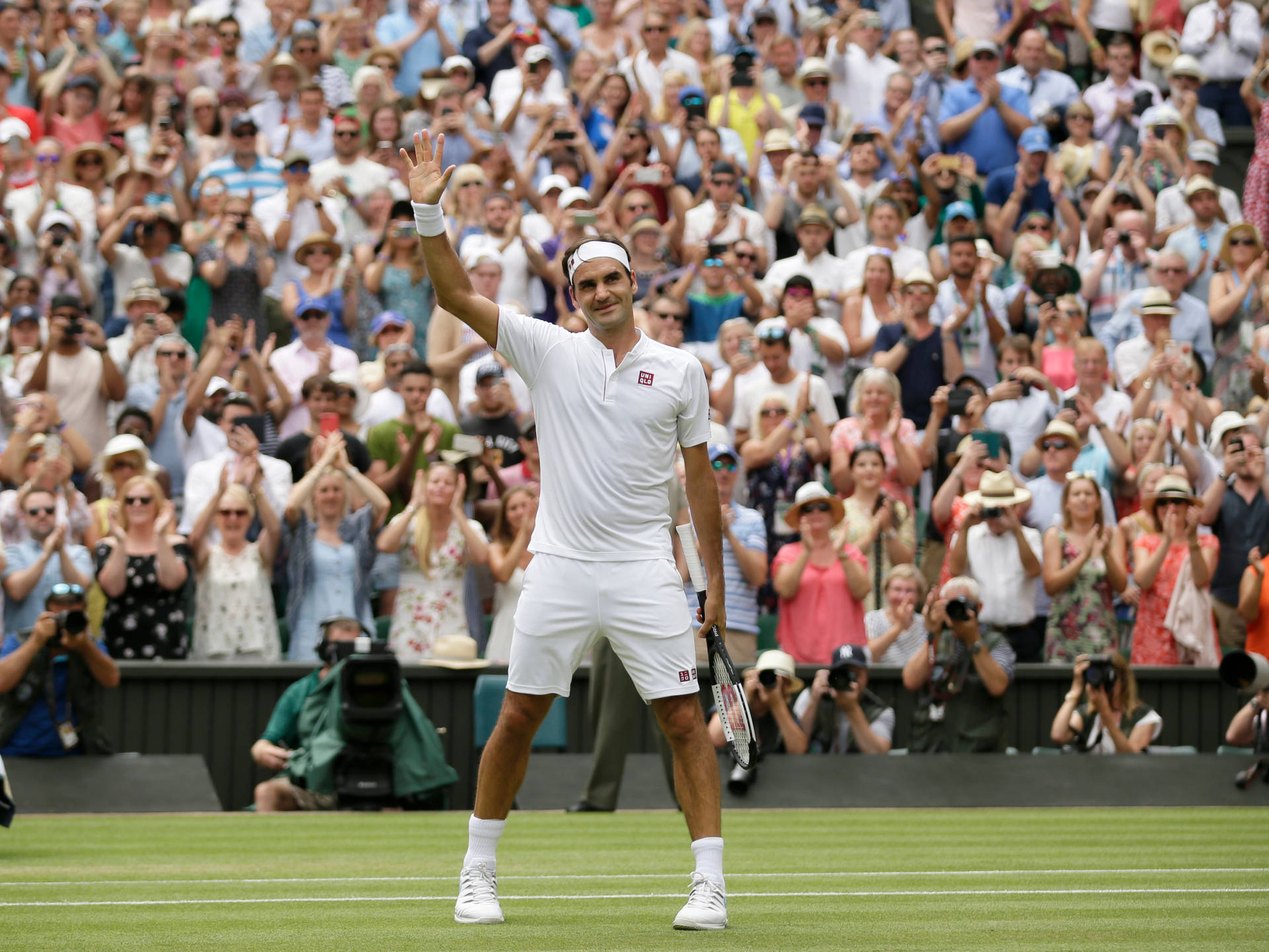 Roger Federer sorrindo com fãs